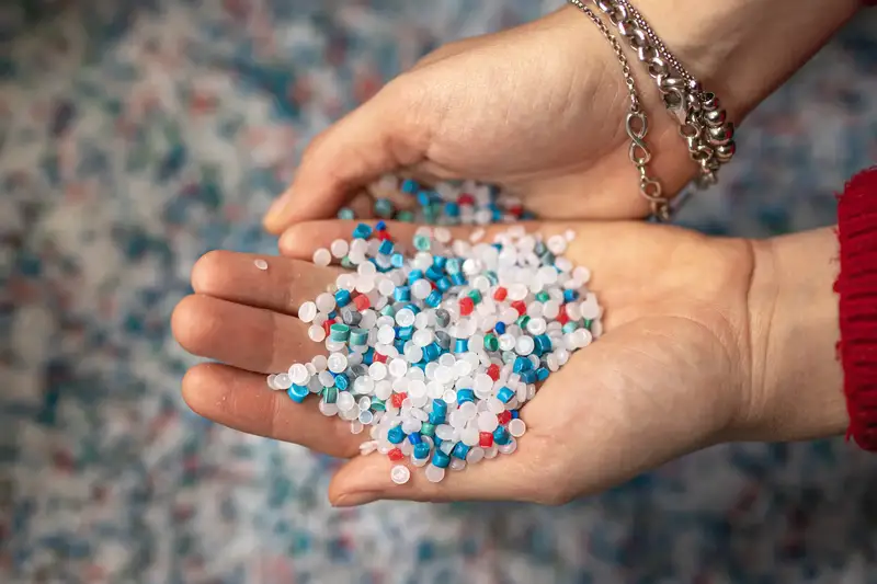 Manos sosteniendo pellets de polietileno, la materia prima de nuestros envases