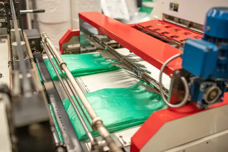 Máquina de confección cortando y soldando bolsas verdes